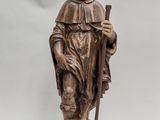 a wooden statue of a man with a hat and a cane