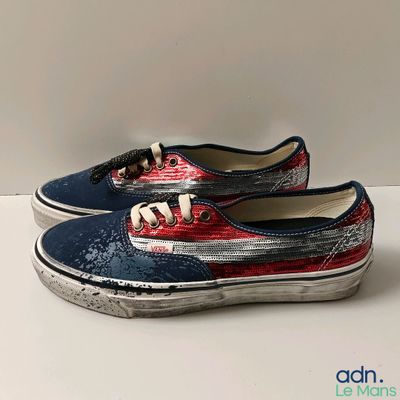 pair of red, white and blue vans style shoes on a white surface