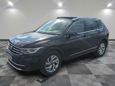 un SUV Volkswagen noir garé dans un garage dont le sol est à carreaux