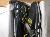 deux paires de chaussures dans une boîte posée par terre