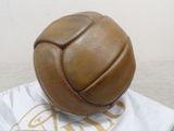 a brown leather ball sitting on top of a white bag