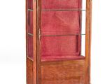 une vitrine ancienne en bois recouverte de velours rouge