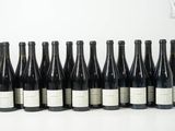 six bouteilles de vin sont alignées sur une table