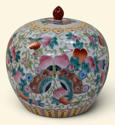 un vase coloré orné de fleurs, posé sur un fond blanc