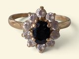 an image of a ring with a black stone surrounded by white diamonds