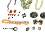 many different types of jewelry on a white surface