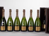 six bouteilles de champagne sont alignées en rang devant une boîte