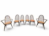 un ensemble de quatre chaises avec accoudoirs et un coussin