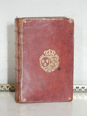 un vieux livre orné d'une couronne, posé sur une table