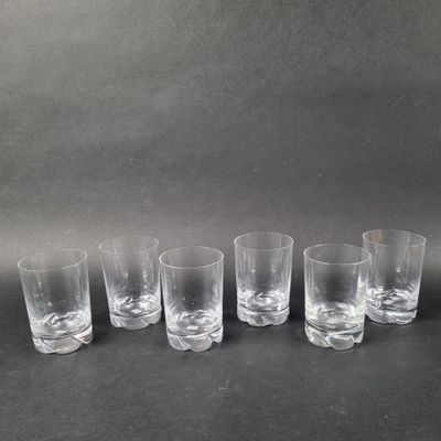 six clear glass tumblers lined up in a row on a black surface