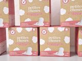 several boxes of cotton pads sitting on top of a white table