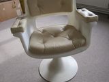 a white chair in a room with a window in the background