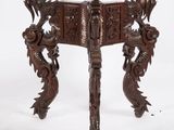 an old wooden table with carvings on the legs and a dragon on the top
