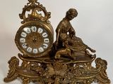 une horloge en or sur laquelle est assise une femme
