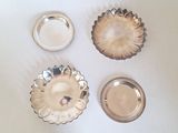 trois plats en argent posés sur un plateau de table blanc