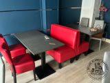 a red booth with a black table and red chairs
