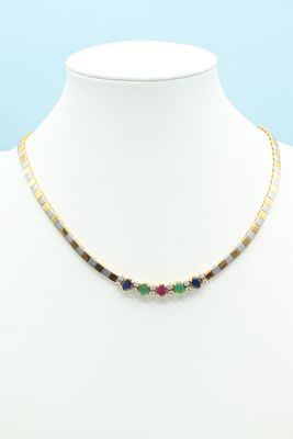 a gold necklace with multi colored stones on a mannequin
