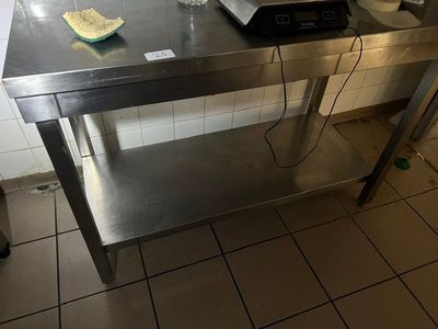 une table sur laquelle est posé un micro-ondes, dans une cuisine