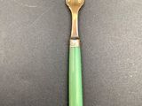 a green fork and knife sitting on top of a black table