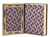 an open book with a purple cover and a gold frame