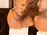 two busts of men sitting on top of a wooden table