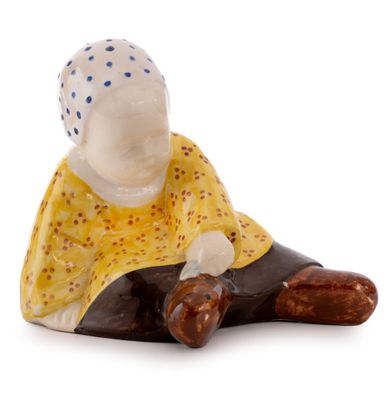 a small figurine of a woman sitting on the ground