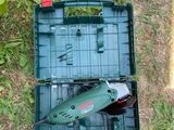 a green box with a drill and a tool in it on the grass