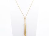 a gold necklace with a tassel on a mannequin neck