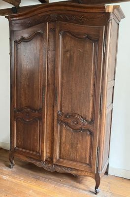a wooden armoire in the corner of a room