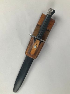 a close up of a knife with a wooden handle on a white surface