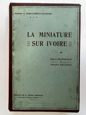 an old book sitting on top of a table next to a white wall