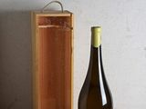 une bouteille de vin posée sur une table à côté d'une caisse en bois