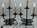 une paire de bougeoirs en métal et en verre noir, avec des bougies blanches dépolies
