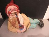 une figurine représentant un clown avec une pipe à la bouche