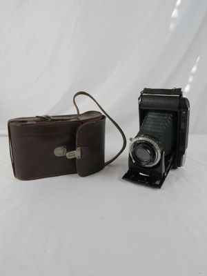 two cameras sitting next to each other on a white surface