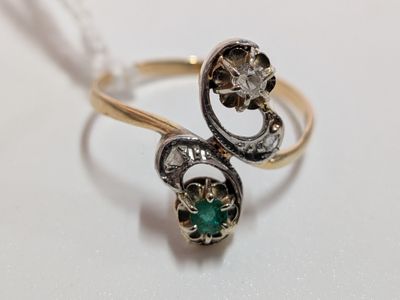 a gold ring with a green stone in it