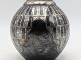 a black vase with a geometric design on it