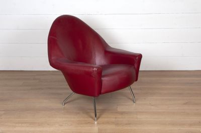 un fauteuil en cuir rouge posé sur un parquet en bois massif