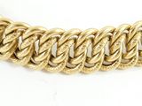 a close up of a gold chain necklace on a white surface