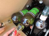 a woman opening a box with bottles of alcohol