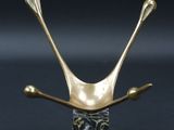une sculpture représentant un oiseau, de couleur or et noir, posée sur un socle en marbre