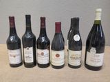 six bouteilles de vin rouge sont alignées sur une table