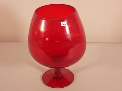 a red glass vase sitting on top of a table