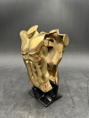 brass horse head sculpture on black base on grey background