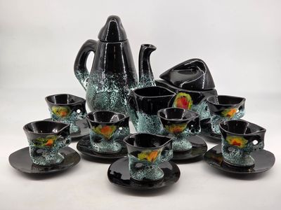 a black and green tea set on a white table