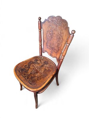 an image of a wooden chair with a carved seat on a white background