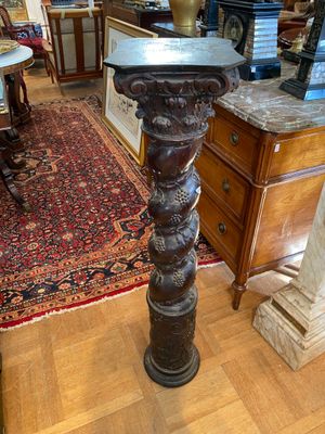 a tall wooden table with a vase on top of it