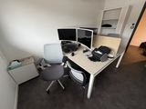 un bureau avec deux écrans d'ordinateur et une chaise placée devant