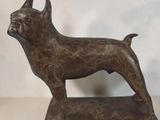 bronze statue of a dog on a stand on a table