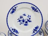 a lot of blue and white plates and bowls on the table